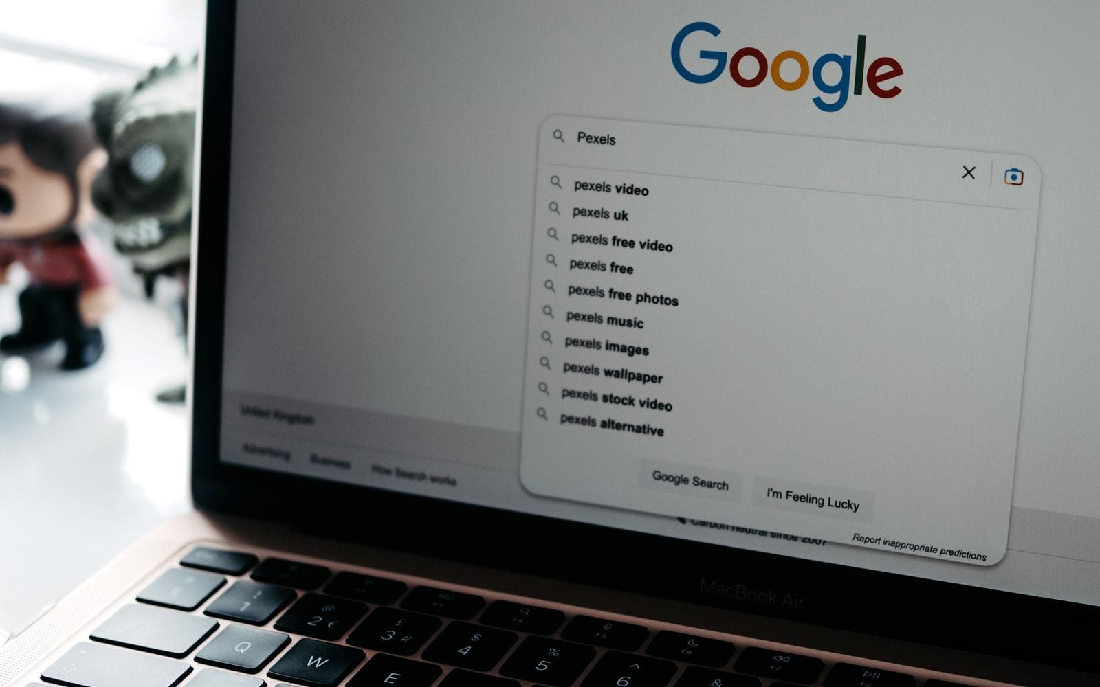 A laptop screen showing the Google search page with suggestions under the search box