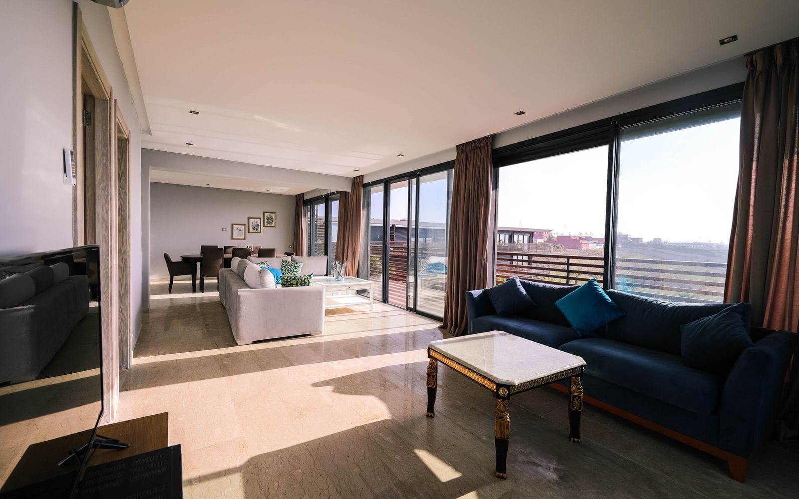 A spacious living room with large windows, a sofa and a city view