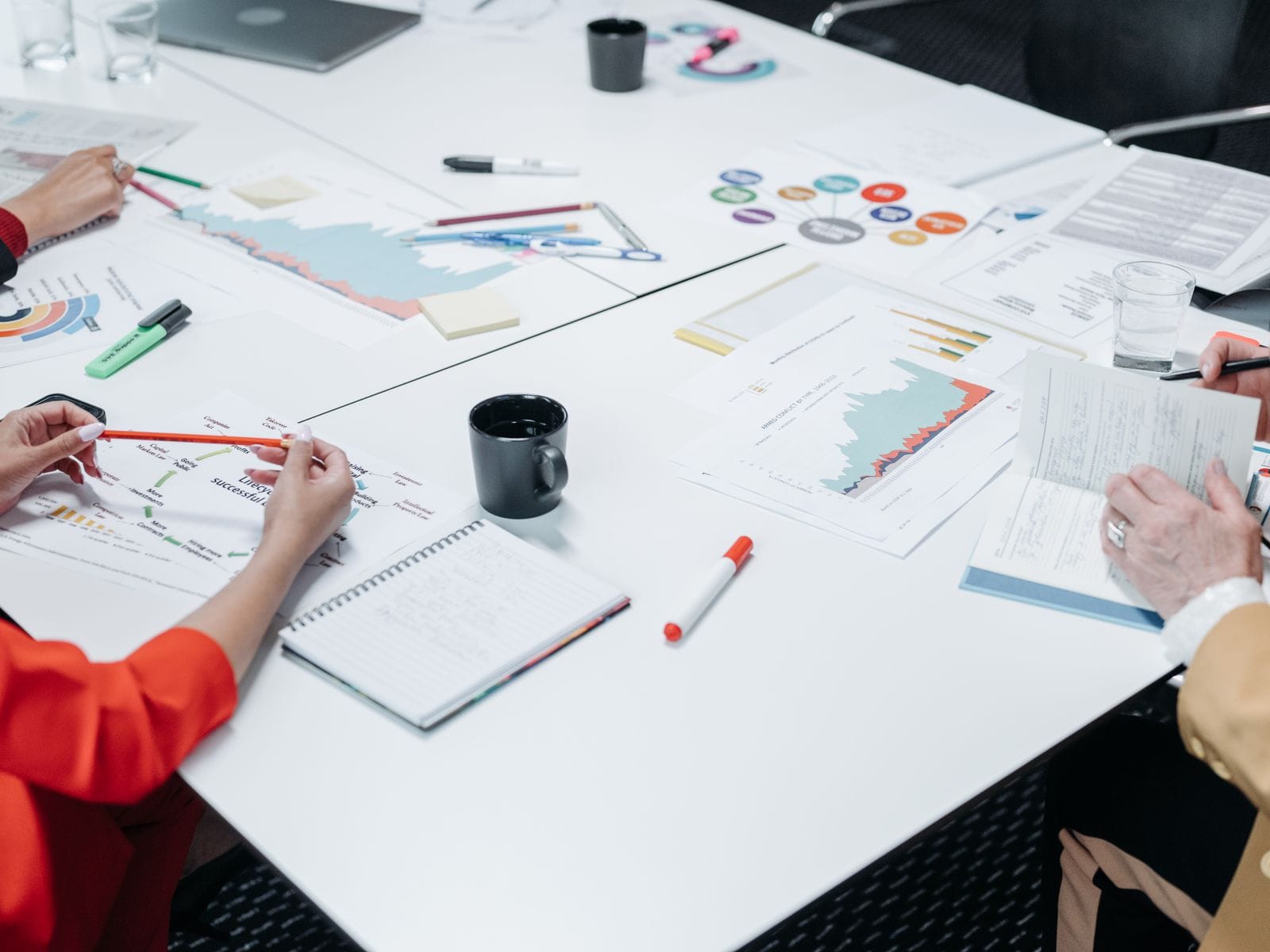 People reviewing printed charts and reports around a meeting table