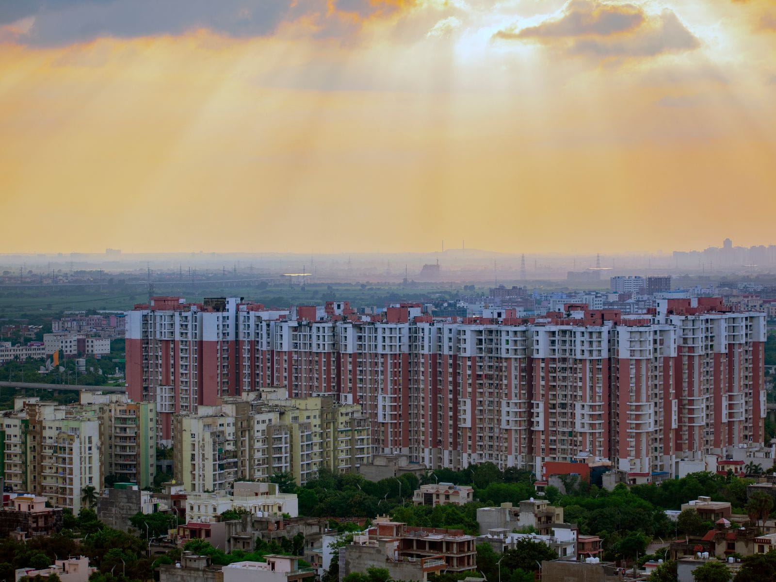 Rows of apartment blocks stretching to the horizon under a golden evening sky